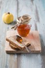 Geléia de marmelo, fatia de pão em tábua de cortar — Fotografia de Stock