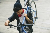 Adolescente che trasporta bici fixie in città, vista aerea — Foto stock
