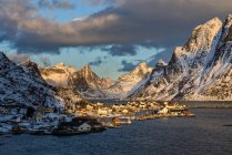 Noruega, Lofoten, Reine al amanecer y montañas cubiertas de nieve - foto de stock