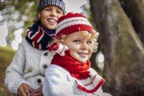Ritratto di ragazzini biondi e suo fratello sullo sfondo che indossano abiti alla moda in maglia in autunno — Foto stock