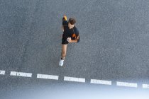 Giovane che corre per strada con marcature — Foto stock