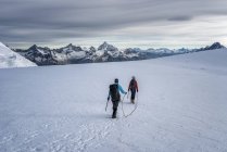 Italy, Gressoney, Alps, Lyskamm, mountaineers hiking in snow covered mountains — Stock Photo