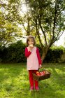 Little girl standing on a meadow and eating apple — Stock Photo