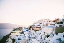Grecia, Santorini, Oia, vista al pueblo al atardecer - foto de stock