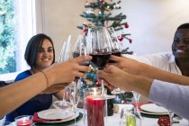 Amici che brindano con il vino durante una cena di Natale — Foto stock