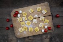 Tagliatelle fatte in casa, ravioli, ripieni di mozzarella di pomodoro sul tagliere — Foto stock