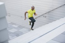 Молодий спортсмен бігати вгору сходів перед будівлі — стокове фото