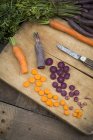 Gehackter lila Dunst und gelbe Karotte auf Holzbrett — Stockfoto
