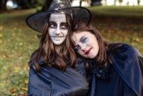 Ritratto di bambine in costumi di Halloween nel parco autunnale — Foto stock
