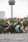 Четыре женщины прыгают во время тренировки на открытом воздухе — стоковое фото