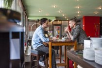 A los jóvenes que socializan en un café - foto de stock