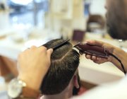 Крупным планом парикмахерская стрижка волос клиента — стоковое фото