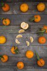Ganze und geschälte Mandarine auf Holz — Stockfoto