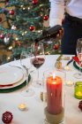 Man serving wine at Christmas dinner — Stock Photo