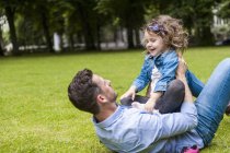 Vater und Tochter spielen auf grüner Wiese im Park — Stockfoto