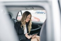 Geschäftsfrau nutzt digitales Tablet im Auto — Stockfoto