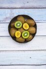 Green and golden kiwis in bowl — Stock Photo
