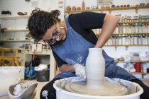 Woman working with pottery wheel in workshop — Stock Photo
