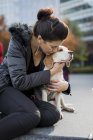 Женщина обнимает свою собаку на улице — стоковое фото
