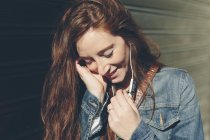 Lächelnde Frau im Freien, Musik hörend — Stockfoto