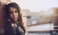 Портрет жінки, що стоїть біля стіни і дивиться на камеру — стокове фото