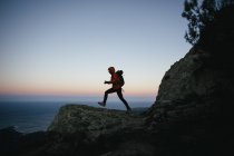 Mulher caminhando no crepúsculo nas montanhas — Fotografia de Stock