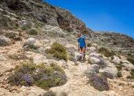 Malta, Ghar Lapsi, Caverna McCartheys, alpinista caminhando nas montanhas — Fotografia de Stock