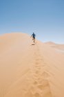 Namibia, desierto de Namib, Sossusvlei, hombre corriendo por una duna - foto de stock