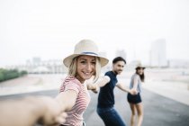Woman holding hands with friends — Stock Photo