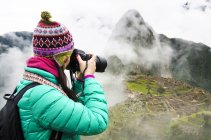 Peru, machu picchu region, reisende frau beim fotografieren der machu picchu zitadelle — Stockfoto