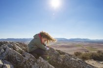 Spagna, Consuegra, bambina seduta su una roccia di montagna — Foto stock