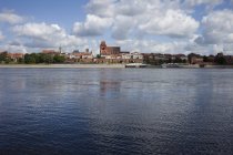 Polonia, Torun, vista al horizonte de la ciudad con el río Vístula en primer plano - foto de stock