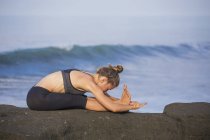 Indonesia, Bali, woman practising yoga at the coast — Stock Photo