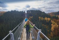 Германия, Рейнланд-Пфальц, Хунсрюк, Саар-Хунсрюк-Штайг, женщина, стоящая на мосту Свинг Гейерлей — стоковое фото