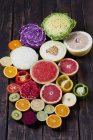 Mitades de diferentes verduras y frutas en madera oscura — Stock Photo