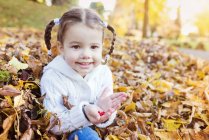 Chica feliz en hojas de otoño - foto de stock