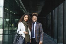 Portrait of two smiling young business people standing in city — Stock Photo