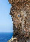 Malta, ghar lapsi, mccartheys höhle, felskletterer auf klippe über meer — Stockfoto