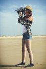 Espanha, El Puerto de Santa Maria, jovem mulher usando câmera de filme velho na praia — Fotografia de Stock