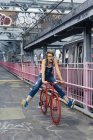 USA, New York City, Williamsburg, mulher com ciclo de corrida vermelho em Williamsburg Bridge — Fotografia de Stock