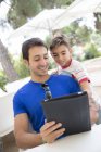 Portrait of father and son using digital tablet — Stock Photo