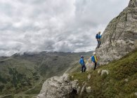 Reino Unido, Distrito de los Lagos, Gran Langdale, escaladores luchando en Pike of Stickle - foto de stock