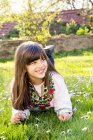 Portrait of smiling girl lying on a meadow — Stock Photo