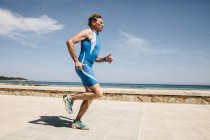 Зрілі кавказька чоловічий triathlet вздовж набережній біля пляжу — стокове фото