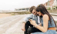 Young couple in love looking at smartphone — Stock Photo
