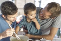 Gay couple baking cake with son — Stock Photo