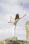 Mulher fazendo exercícios de ioga em uma montanha — Fotografia de Stock