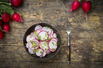 Органічної редьки салат в миску зеленою цибулею — стокове фото