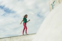 Mulher balanceamento na parede no skatepark — Fotografia de Stock
