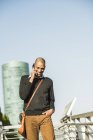 Lächelnder Mann im Freien per Handy — Stockfoto